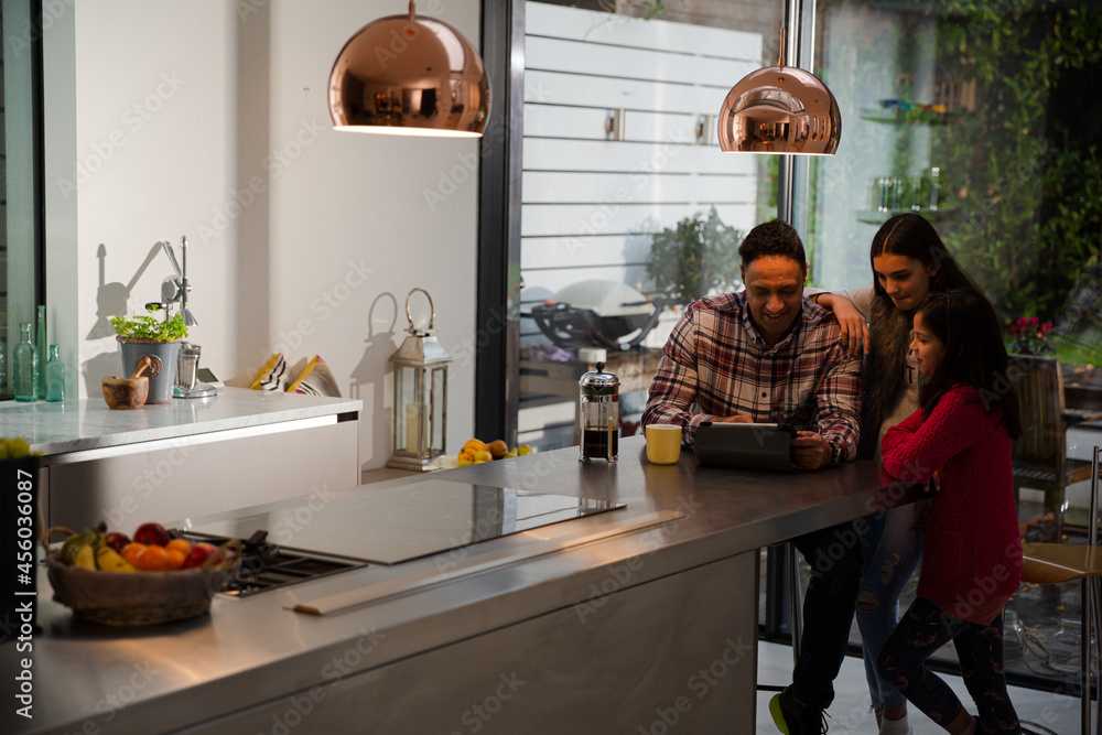 Family using digital tablet at kitchen table Family using digital tablet at kitchen table