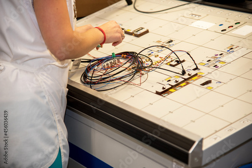 Obraz na płótnie the worker tests for the definition of quality part of the wiring for cars at a modern plant in a production workshop w salonie