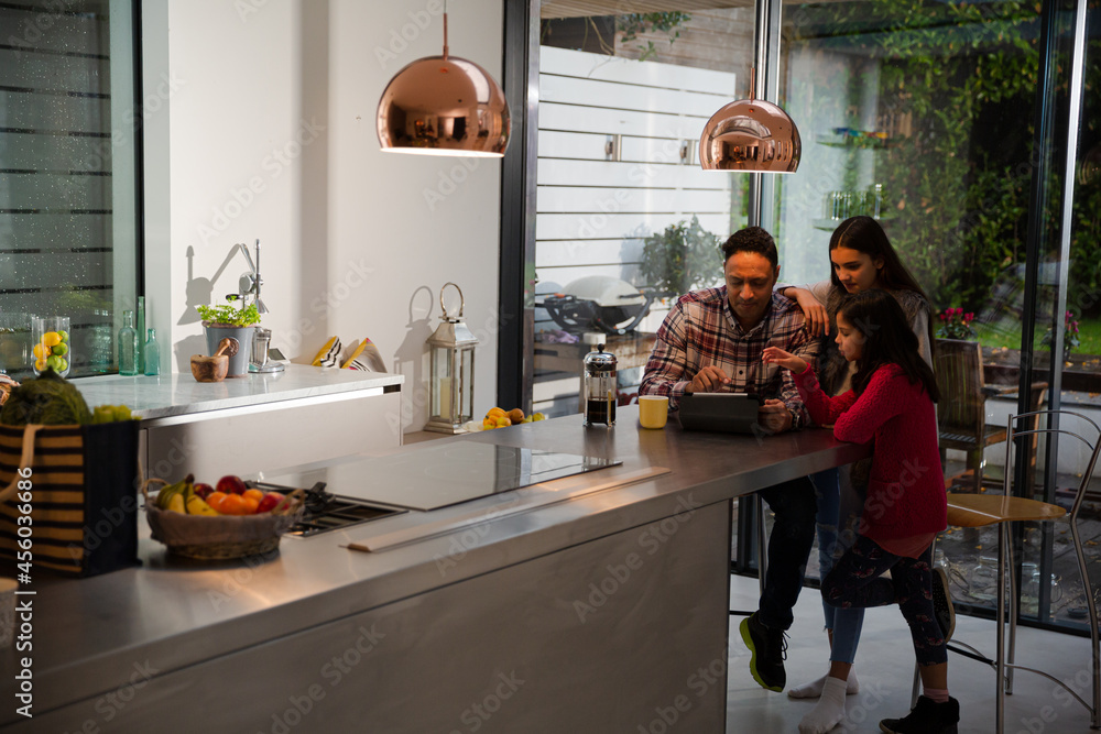 Family using digital tablet at kitchen table Family using digital tablet at kitchen table