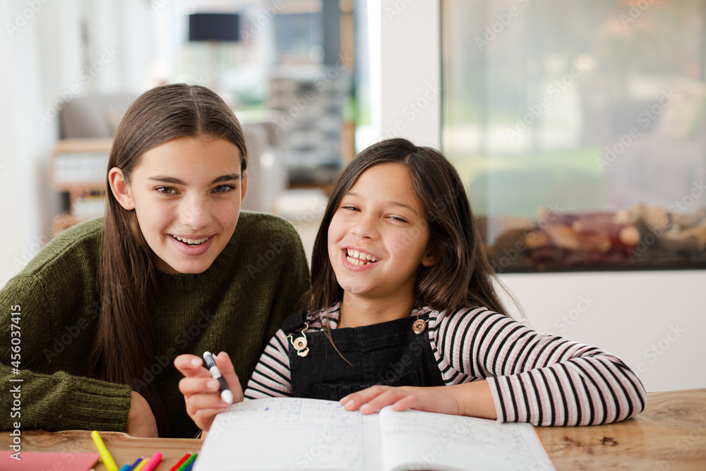 Girl helping young sister with homework Girl helping young sister with homework