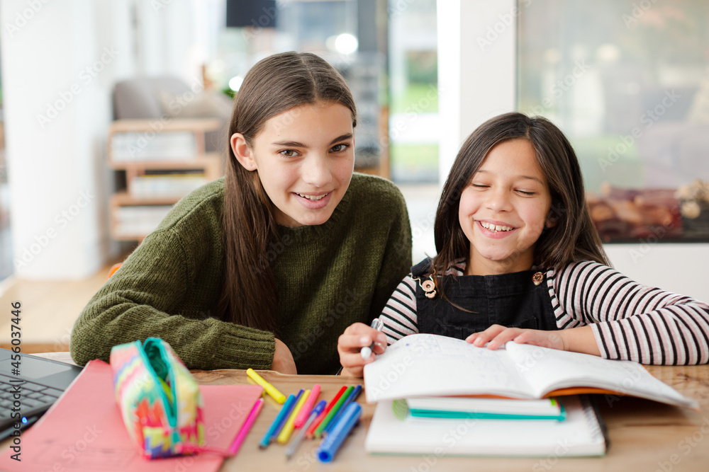 Girl helping young sister with homework Girl helping young sister with homework