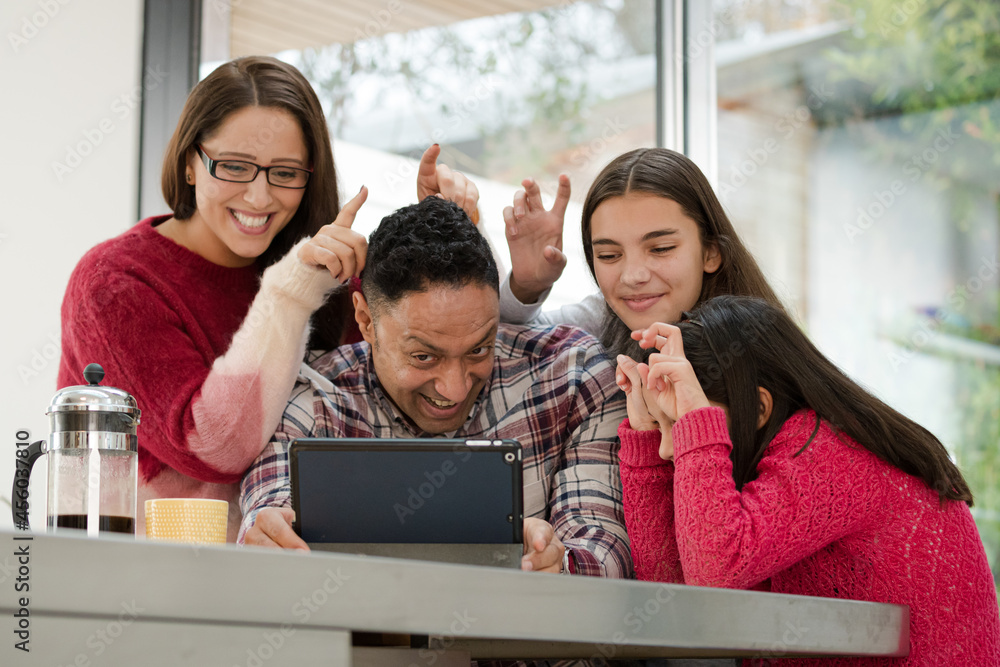 Happy family using digital tablet at kitchen table Happy family using digital tablet at kitchen table
