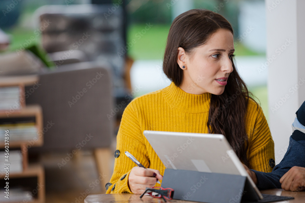 Couple using digital tablet at kitchen island Couple using digital tablet at kitchen island