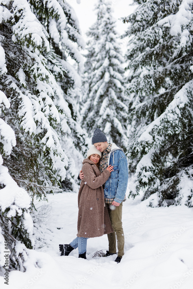 cute couple embracing in winter forest. cute couple embracing in winter forest.