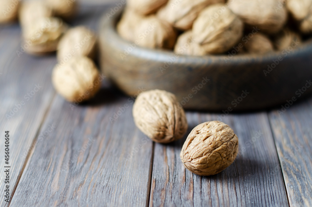 Walnuts on a dark brown wooden background. Close up. Selective focus, side view. Copy space. Walnuts on a dark brown wooden background. Close up. Selective focus, side view. Copy space.
