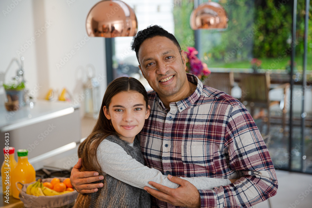 Portrait happy father and daughter hugging in kitchen Portrait happy father and daughter hugging in kitchen