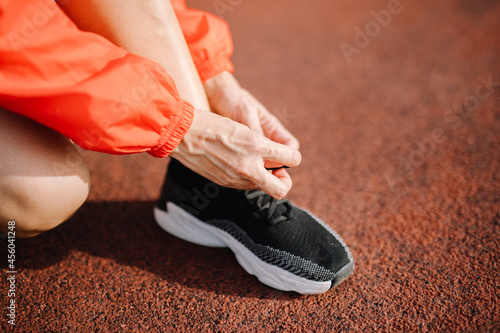 Feet of a female runner who is stepping on the running field with strength. Exercising in the summer with running methods to keep your body healthy.