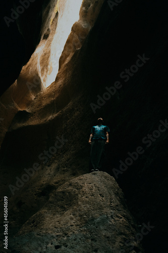man stands on a stone in a cleft