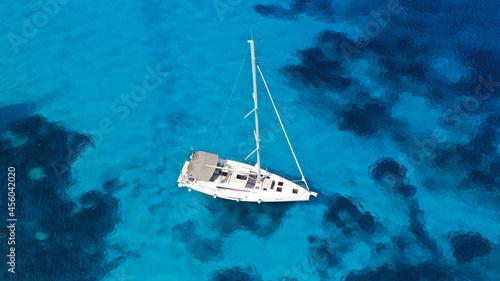 Aerial drone photo of beautiful sail boat anchored in tropical exotic island bay with turquoise clear sea © aerial-drone