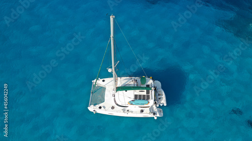 Aerial drone photo of beautiful catamaran sailing yacht anchored in tropical exotic turquoise sea exotic bay