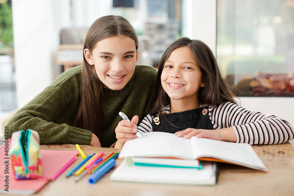 Obraz premium Girl helping young sister with homework