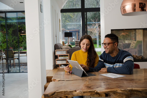 Couple using digital tablet at kitchen island