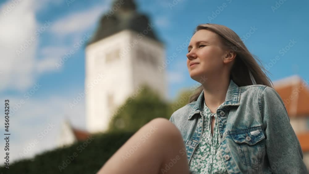 Woman resting against church in old Tallinn. Woman resting against church in old Tallinn.