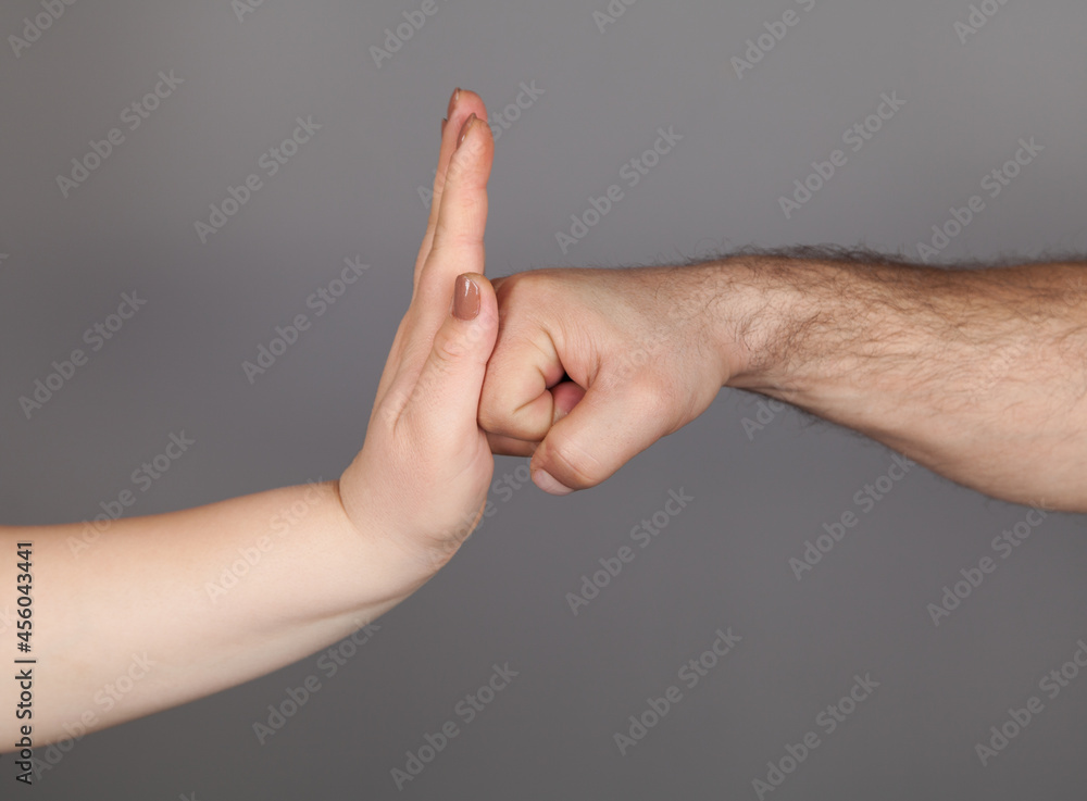 Stop violence against women campaign. Woman using hand palm to stop man's punch from attack isolated, on gray background. Stop violence against women campaign. Woman using hand palm to stop man's punch from attack isolated, on gray background.