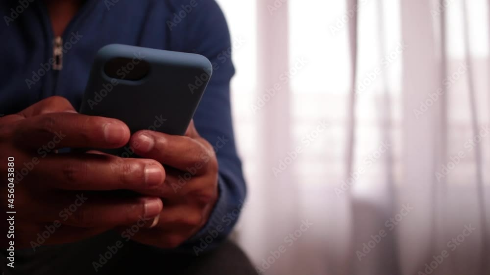 Young latin man talking on the phone at home and smiling. Latin American man having a phone call sitting on the Sofa at home. Lifestyle concept. Young latin man talking on the phone at home and smiling. Latin American man having a phone call sitting on the Sofa at home. Lifestyle concept.