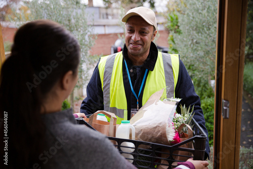 Woman greeting food deliveryman at front door