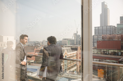 Two businessmen talking on balcony