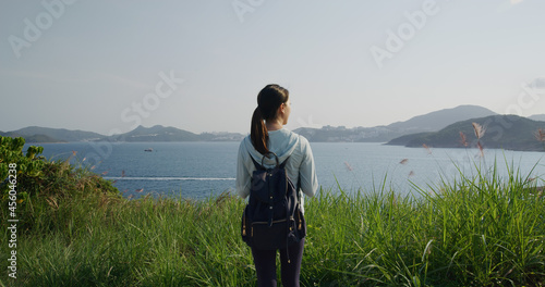 Woman go hiking and stand at the top of mountain