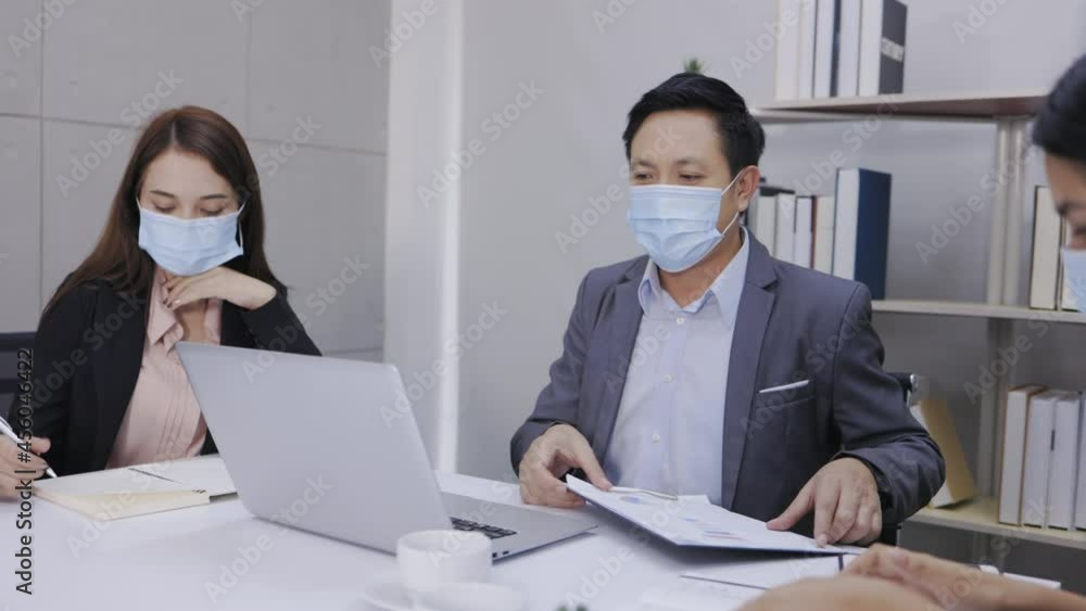Motivated middle-aged Asian businessman and two young businesswomen happily exchanged ideas for business plans, enjoying working together at the office. Motivated middle-aged Asian businessman and two young businesswomen happily exchanged ideas for business plans, enjoying working together at the office.