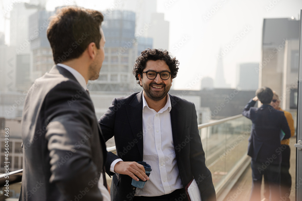Two businessmen talking on balcony Two businessmen talking on balcony