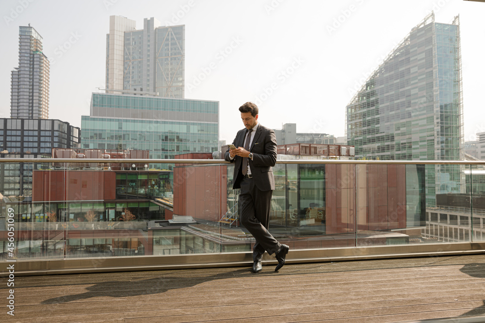 Businessman using smarpthone on balcony Businessman using smarpthone on balcony