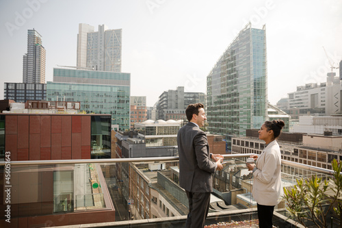 Businessman and businesswoman talking on balcony