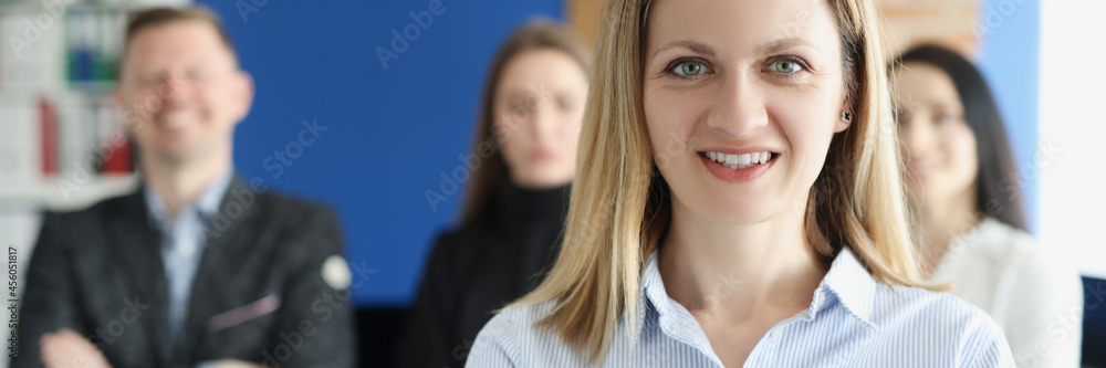 Portrait of young successful business woman on background of colleagues Portrait of young successful business woman on background of colleagues