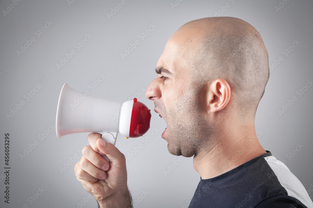 Caucasian man screaming with megaphone. Caucasian man screaming with megaphone.