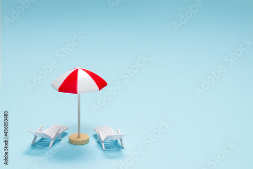 Travel concept. Sun lounger  red umbrella on a blue background.