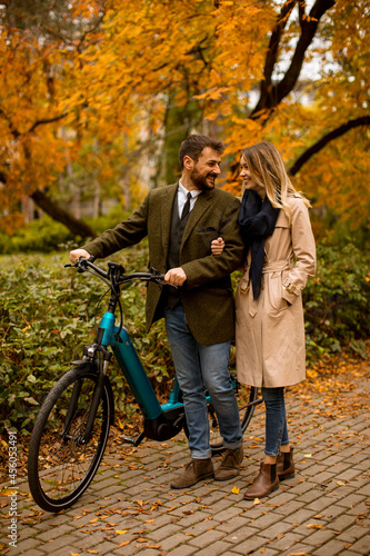 Young couple in the autumn park with electrical bicycle © BGStock72