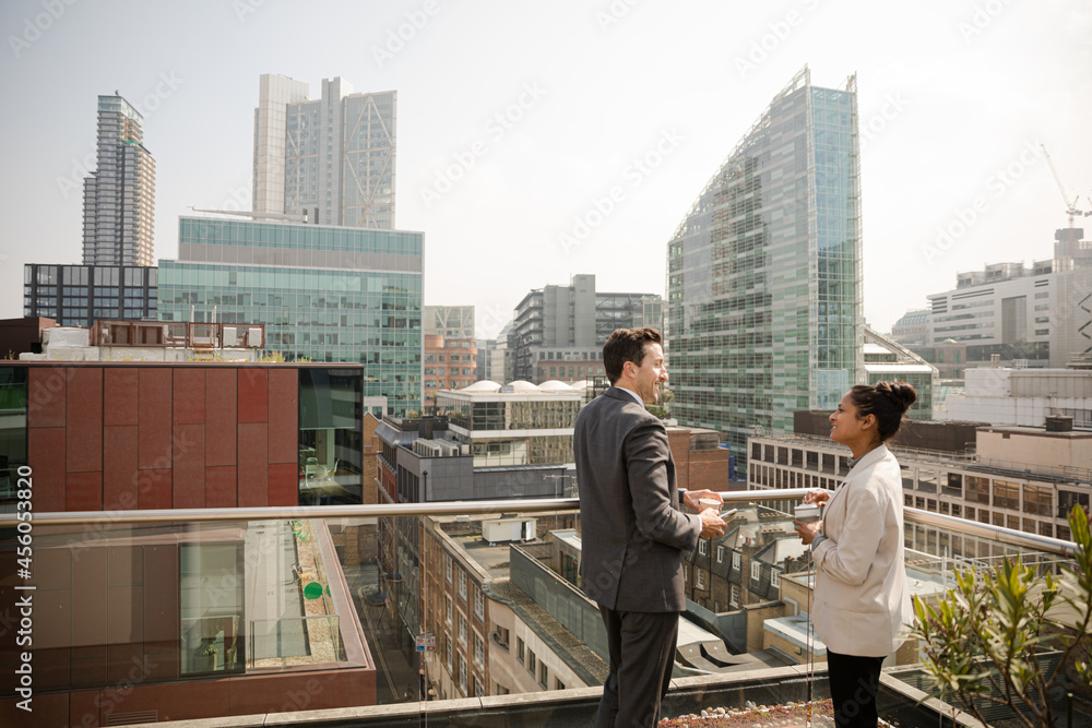 Businessman and businesswoman talking on balcony Businessman and businesswoman talking on balcony