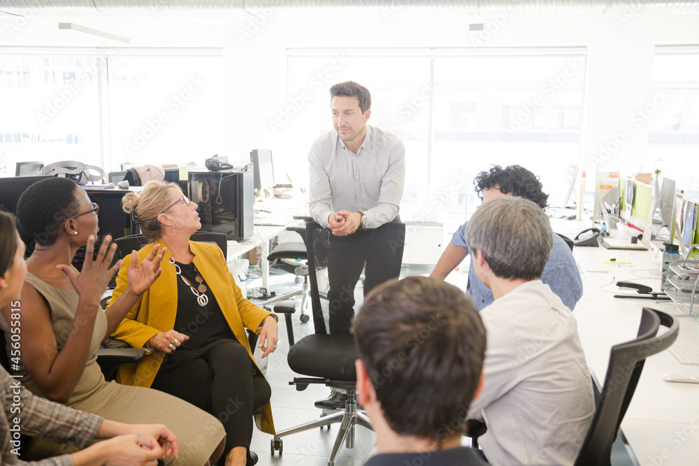 Business people meeting at computer in open plan office Business people meeting at computer in open plan office
