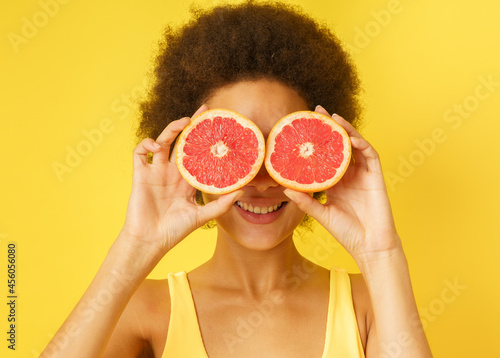 Happy happy girl plays with red orange slices photo