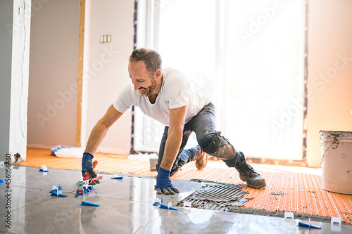nice handyman install tile on the floor © Louis-Photo