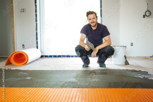 Man worker install orange roll membrane waterproofing on the floor photo