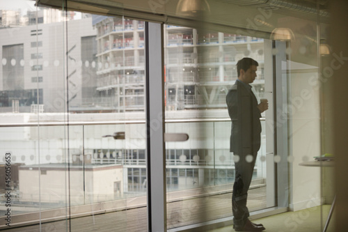 Businessman standing by window in conference room