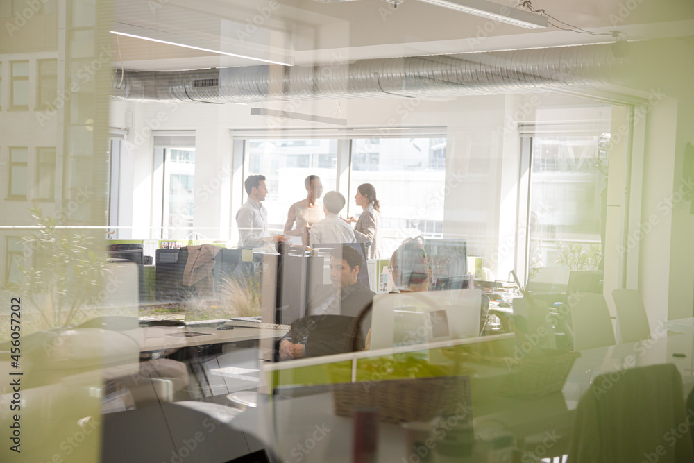Business people talking in open plan office Business people talking in open plan office