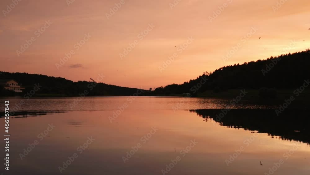 Landscape with lake ripples, sky horizon, forest silhouette and flying birds. Serene tranquil nature after sunset, in dusk. Landscape with lake ripples, sky horizon, forest silhouette and flying birds. Serene tranquil nature after sunset, in dusk.