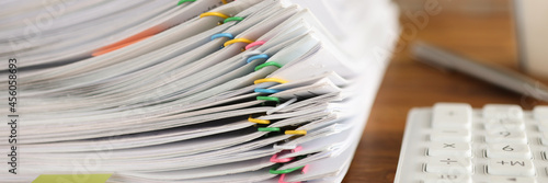 Fotografie Lot of documents fastened with multicolored paper clips lying on table closeup