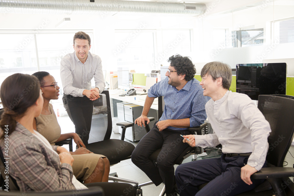 Business people meeting at computer in open plan office Business people meeting at computer in open plan office