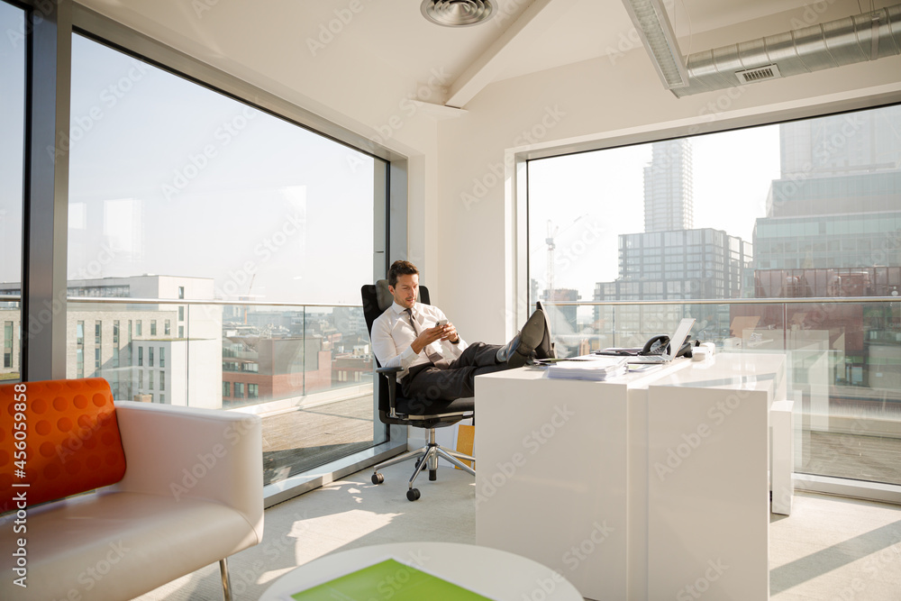 Businessman relaxing at desk in modern office Businessman relaxing at desk in modern office