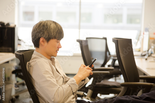 Portrait confident businessman using smartphone in office