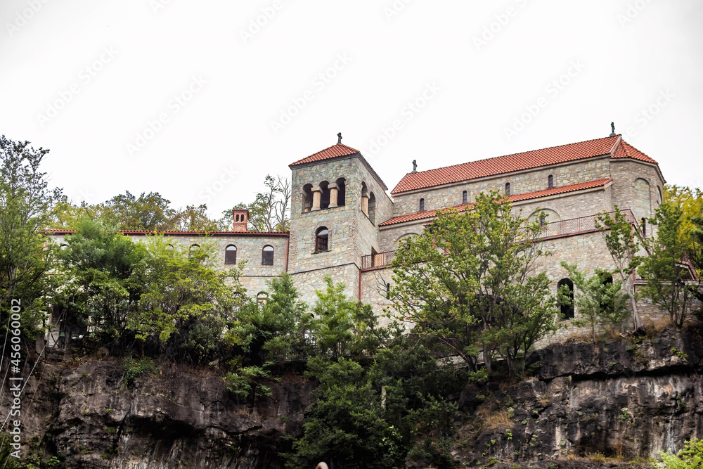 View of Mghvimevi Georgian Orthodox monastery in region of Imereti, near the town of Chiatura, partly carved into rock