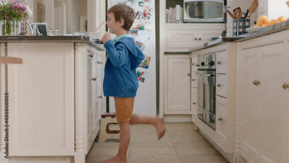 happy little boy taking cookie sneaky child stealing biscuit in kitchen at home happy little boy taking cookie sneaky child stealing biscuit in kitchen at home
