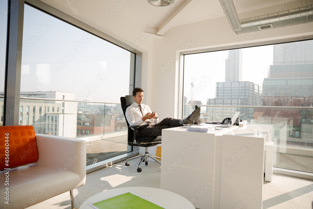 Businessman relaxing at desk in modern office Businessman relaxing at desk in modern office