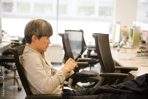 Portrait confident businessman using smartphone in office