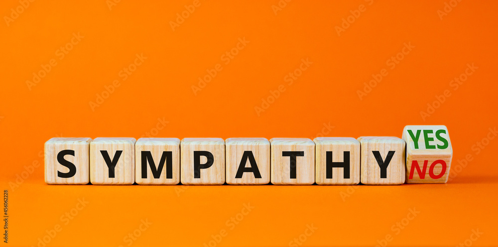 Fototapeta premium Sympathy yes or no symbol. Turned a wooden cube and changed words 'sympathy no' to 'sympathy yes'. Beautiful orange background. Business and sympathy yes or no concept, copy space.