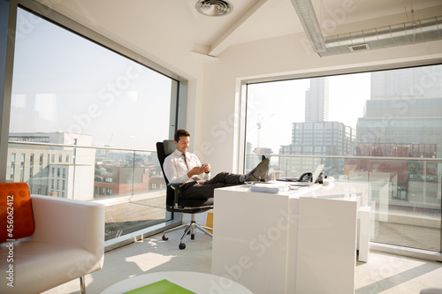 Businessman relaxing at desk in modern office