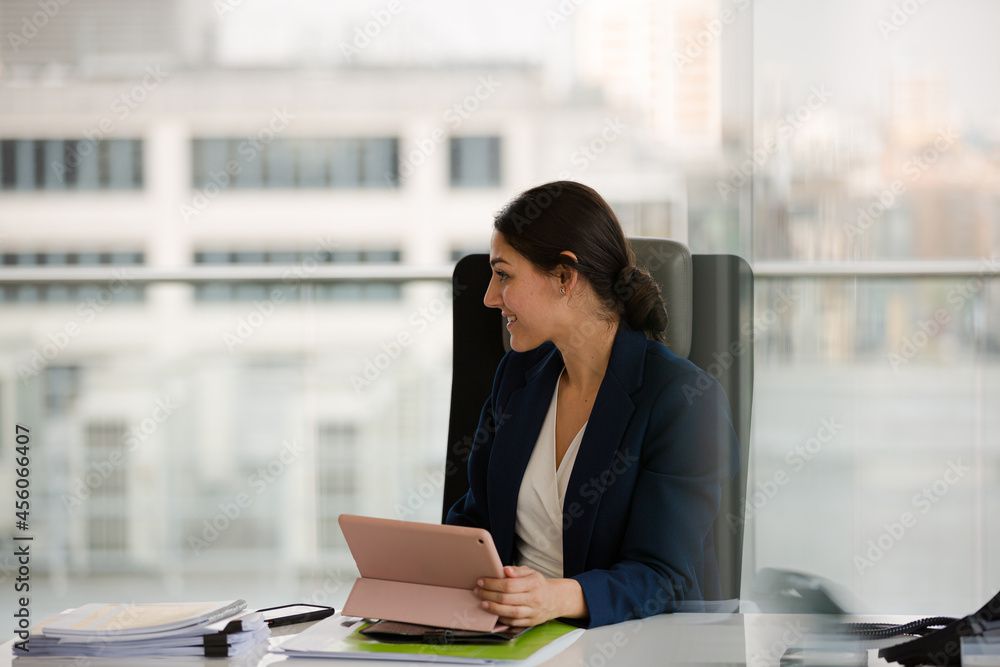 Businesswoman using smartphone and tablet computer at desk Businesswoman using smartphone and tablet computer at desk