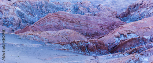 Panoramic image of the barren desert landscape with bare rocks in the Moon valley (Valle de la Luna) in the vicinity of San Pedro de Atacama in the blue hour before sunrise
